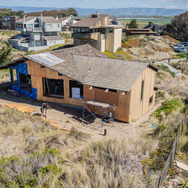 Drone view of residential remodel with roof and exterior walls visible