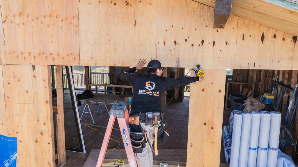 Contractor installing exterior sheathing during residential remodel