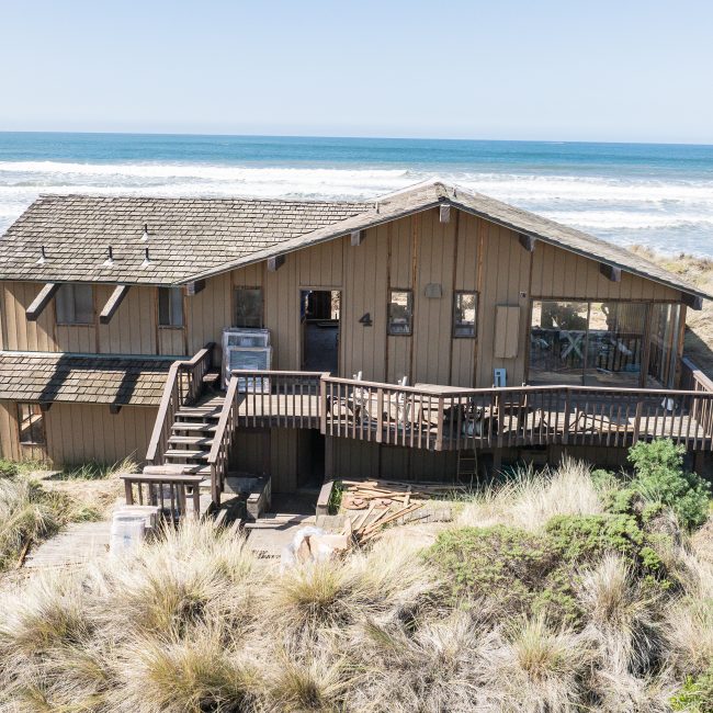 Coastal home exterior renovation with deck and stairs built by DeCamp Construction