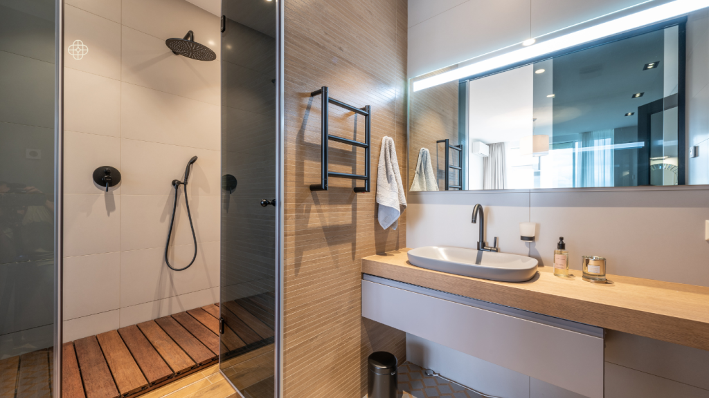 Modern bathroom remodel with walk-in shower, vanity, and wood finishes by DeCamp Construction