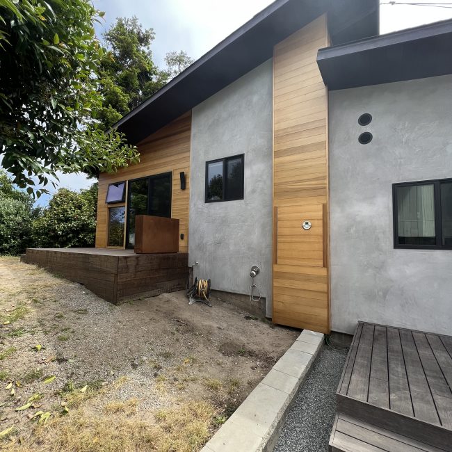 Modern ADU exterior with wood siding and gravel yard