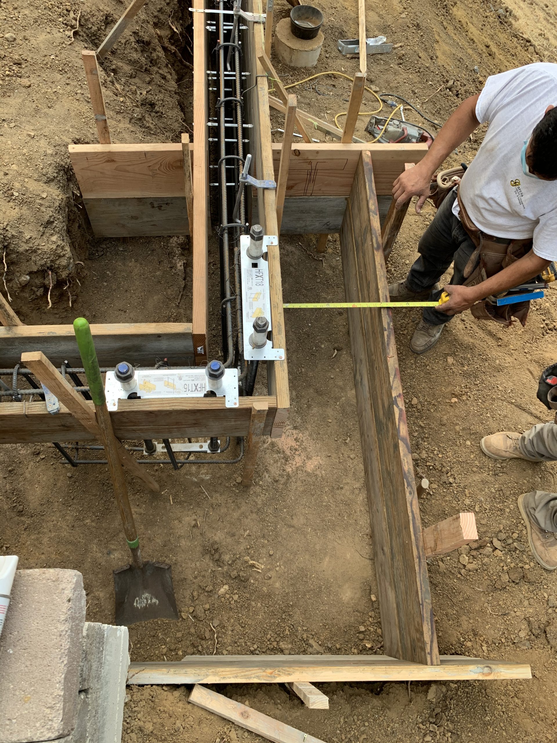 Contractor measuring footing layout for foundation installation