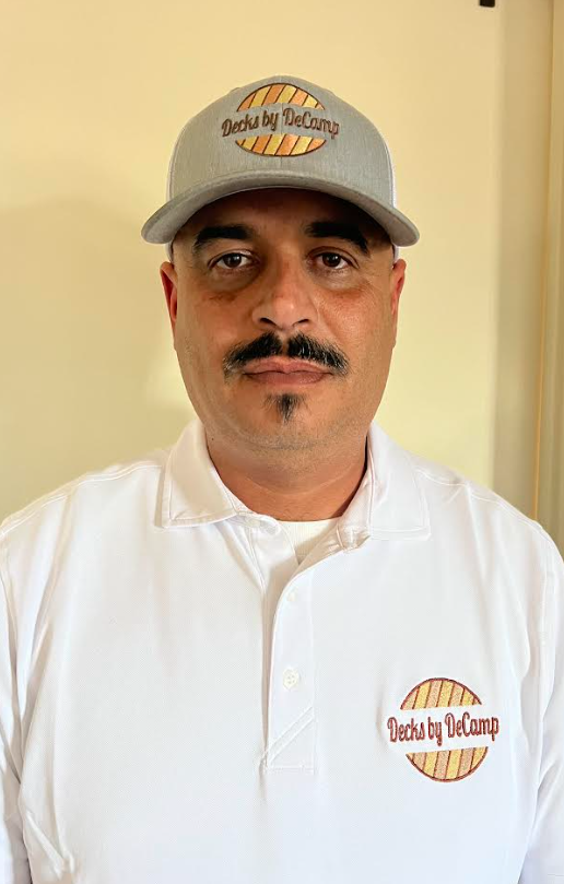 Portrait of Jose wearing white shirt and baseball cap indoors